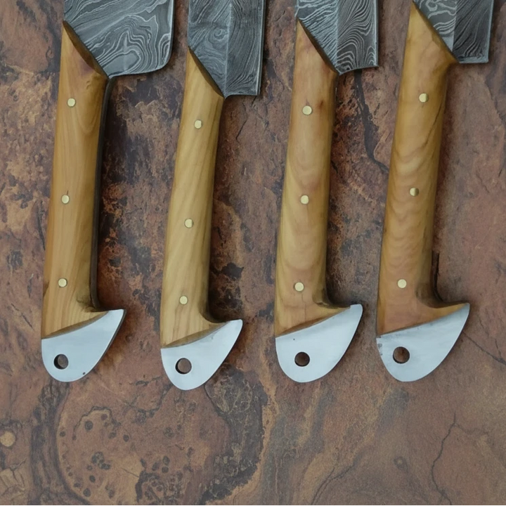 Luxury forged kitchen cutlery with angular blade shapes and artisan natural wood handle finishes.