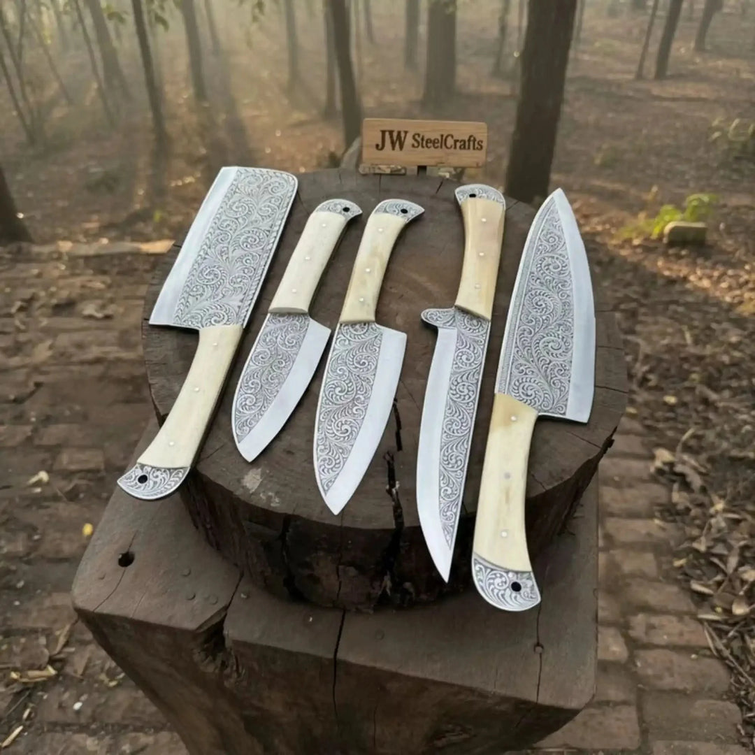 Custom Damascus Chef Set Of Knives With Decorative Handles Displayed On A Wooden Log In A Forest Setting.