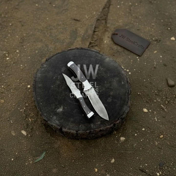 Artisan utility and hunting knives with dark rosewood handles on wooden stump