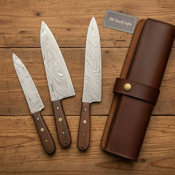 Handcrafted Damascus kitchen cutlery displayed beside a brown leather knife carrying roll.