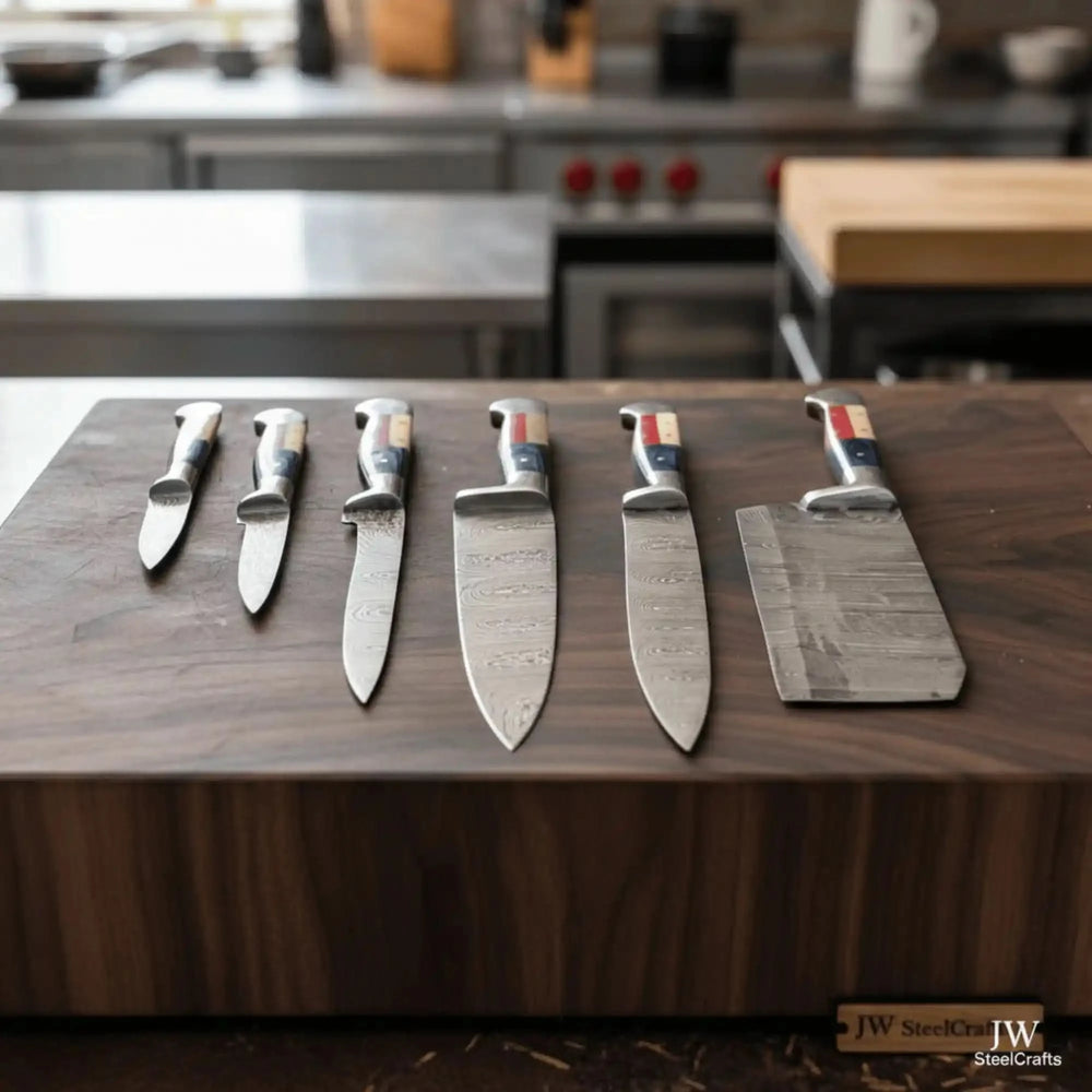 Eye-level view of five handforged Damascus kitchen knives including cleaver with patriotic Texas flag tricolor handles standing upright on a walnut wood board in a modern kitchen setting
