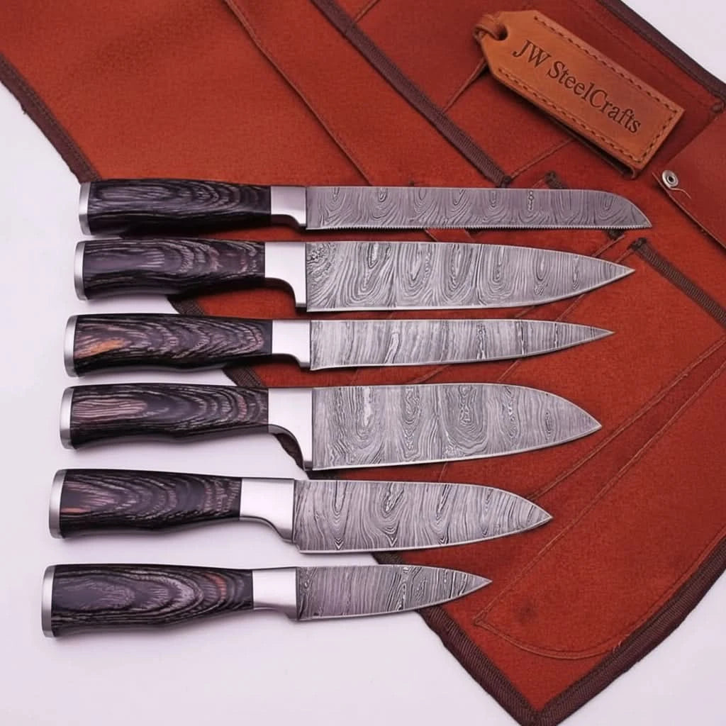 Six handcrafted Damascus steel kitchen knives with dark woodgrain handles displayed horizontally on orange leather backdrop.