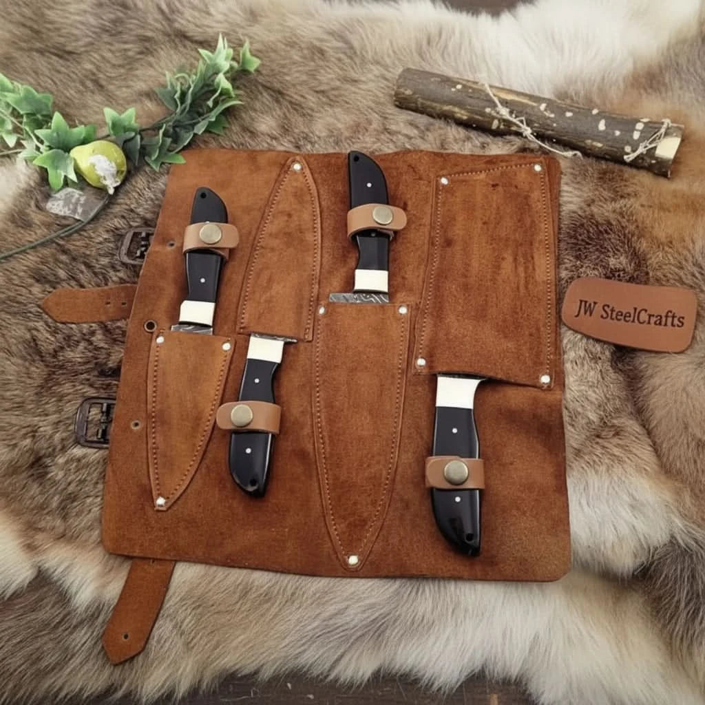 Kitchen knives with Damascus pattern blades and smooth black ergonomic handles.