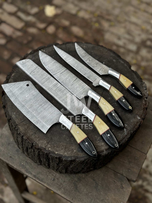 Set of five Damascus knives on a wooden block with a blurred background