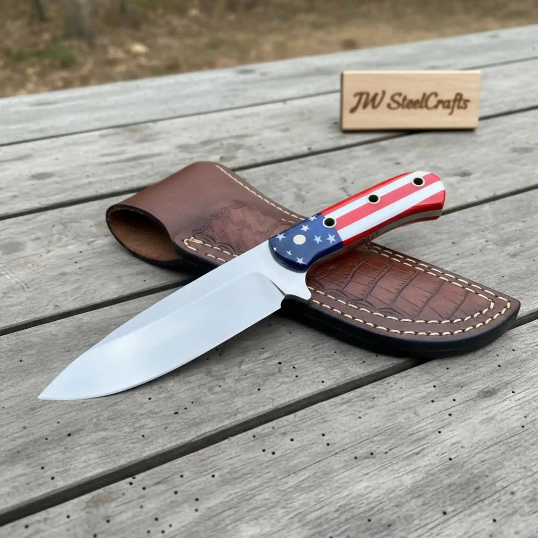 Damascus Steel Chef Knife With American Flag Forked Blade Knife With American Flag Handle On A Wooden Surface, Accompanied By A Leather Sheath
