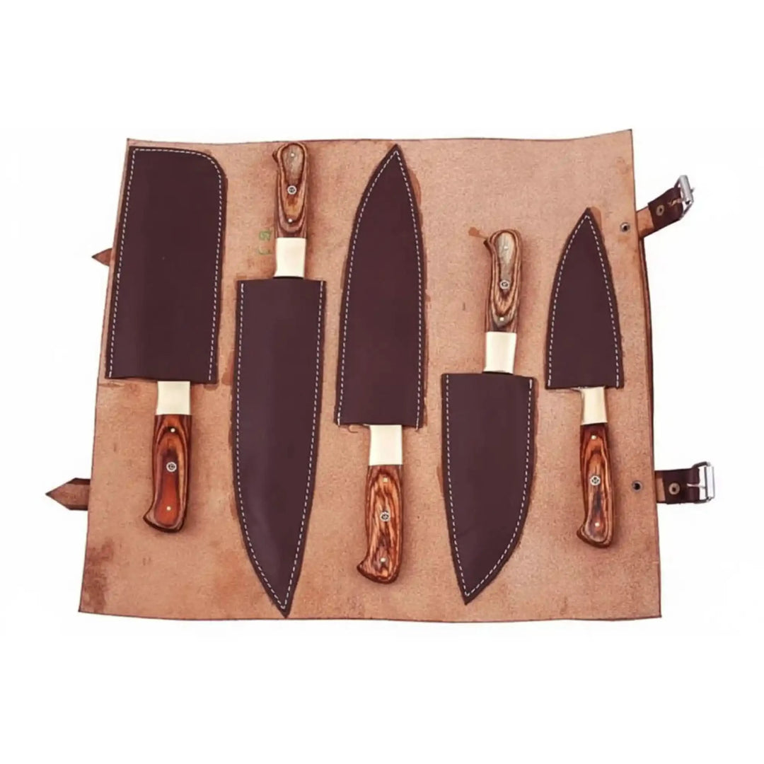 Five handcrafted Damascus steel kitchen knives with polished rosewood handles and brass bolsters displayed diagonally on white background.