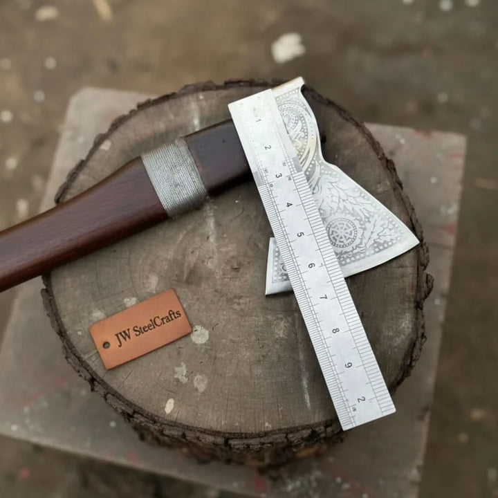 Emberclaw-inspired Viking battle hatchet displaying artistic Nordic carvings and wrapped leather handle craftsmanship.