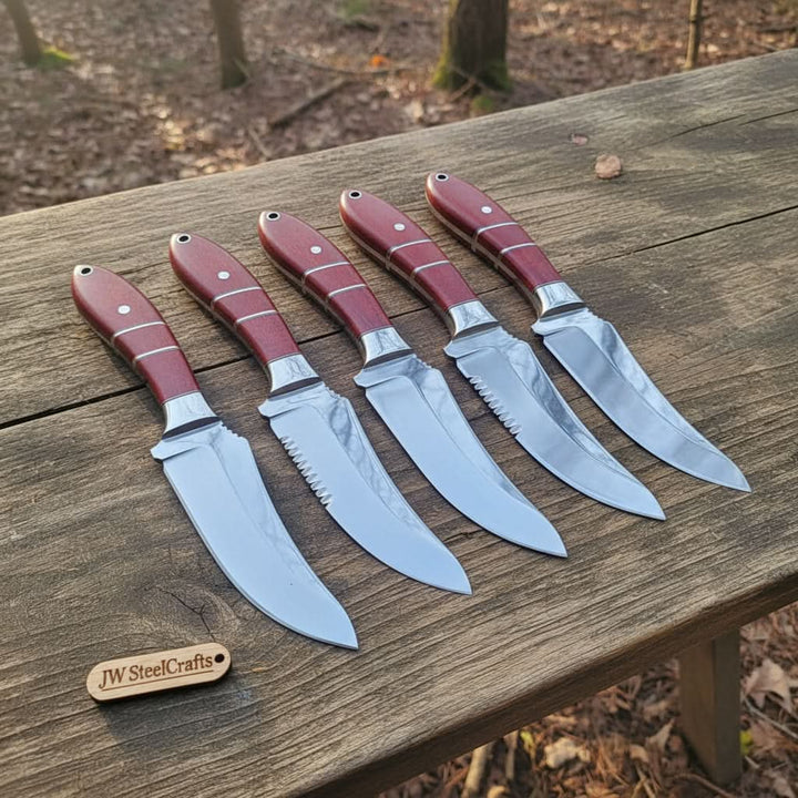 Mirror-polished blades and burgundy micarta handles with silver liner spacers define this five-skinner set on a forest stump