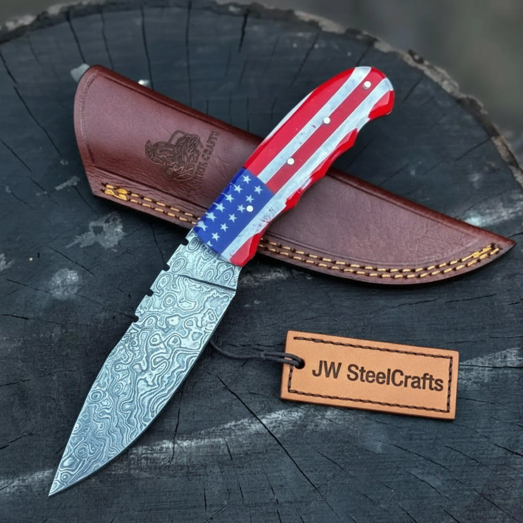 Patriotic custom fixed blade knife featuring an American flag-style handle and patterned steel blade beside a stitched sheath.