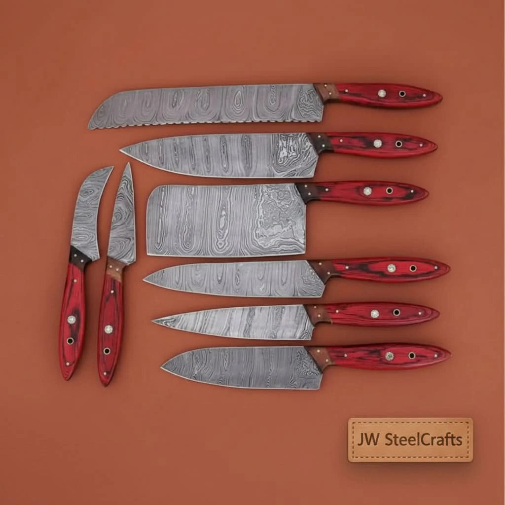 Decorative Damascus culinary blades arranged neatly on reclaimed wood background for luxury artisan presentation.