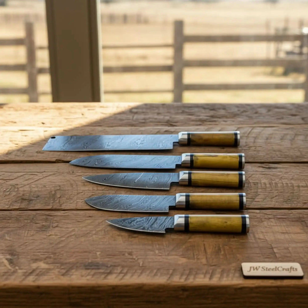 Olive wood Damascus chef knives displayed on rustic weathered wood in natural light.
