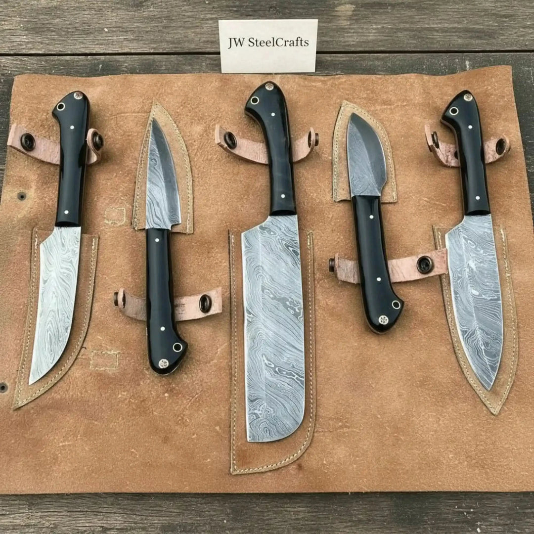 Handmade Damascus chef and utility knife set with black Pakka wood handles and full tang patterned steel blades.