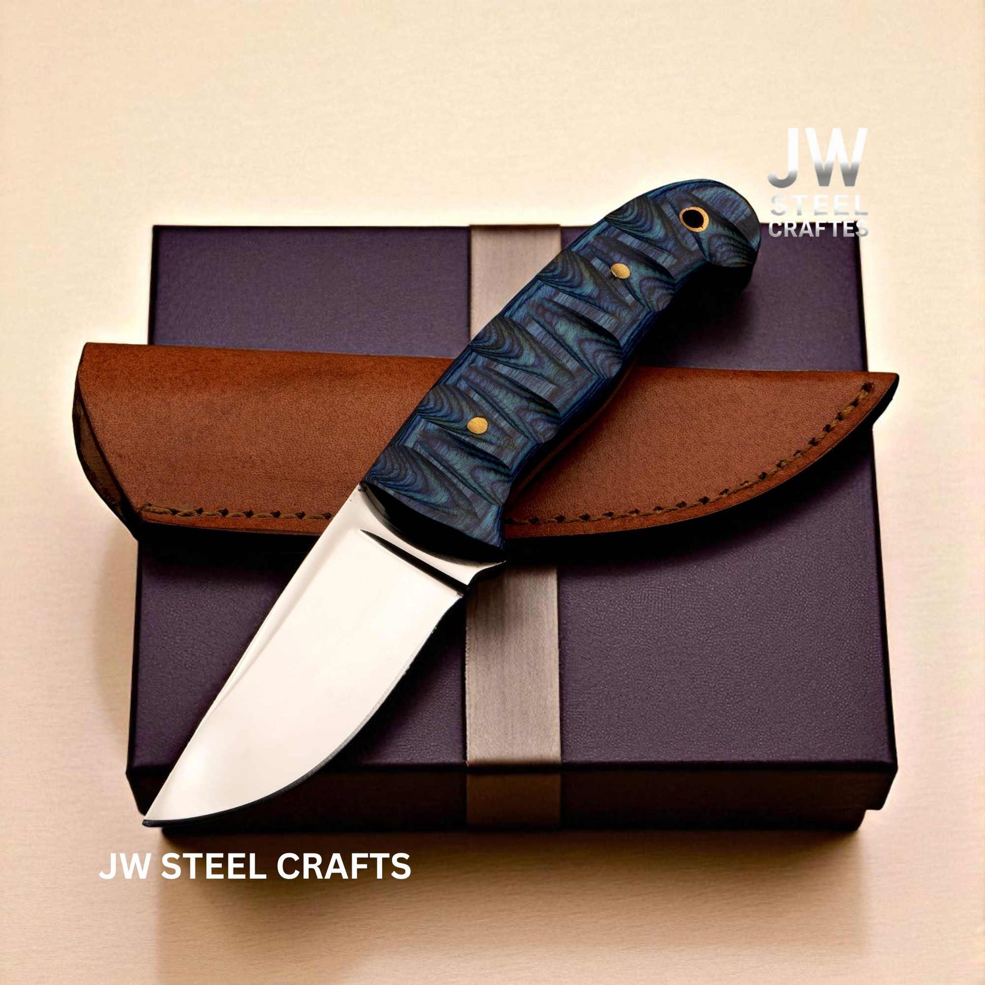 Knife with blue handle and brown sheath on a purple box, branded 'JW Steel Crafts'.