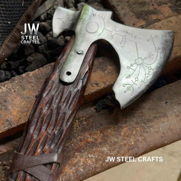 Hand engraved carbon steel Viking double-bit axe with Norse rune etching and engraved hardwood handle on white background