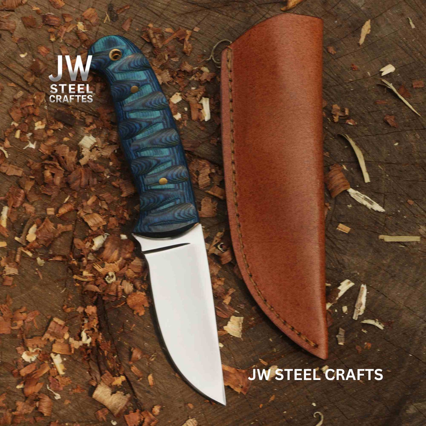 Forked-tongue knife with blue handle and brown sheath on a wooden surface, branded 'JW Steel Crafts'.