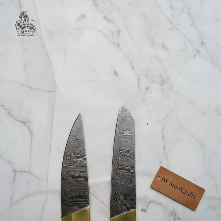 "Exquisite Damascus steel blade textures of custom-made kitchen knives, displayed on a white marble background, showcasing JW Steel Crafts&