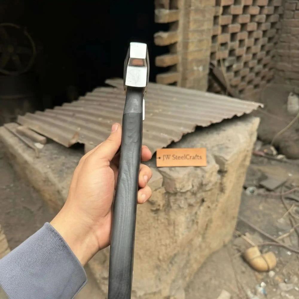 Hand-Forged Nordic Ulu-Style Axe Handcrafted And Displayed While Being Held By A Hand In An Outdoor Setting.