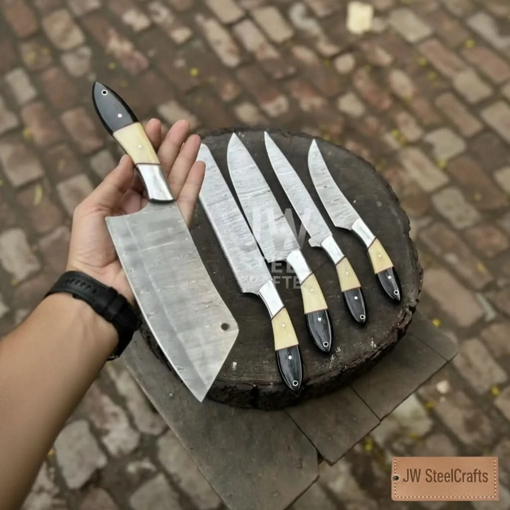 A person holding a large Damascus steel cleaver from a 5-piece handmade knife set, featuring premium camel bone and black micarta handles, displayed over a rustic wooden log.