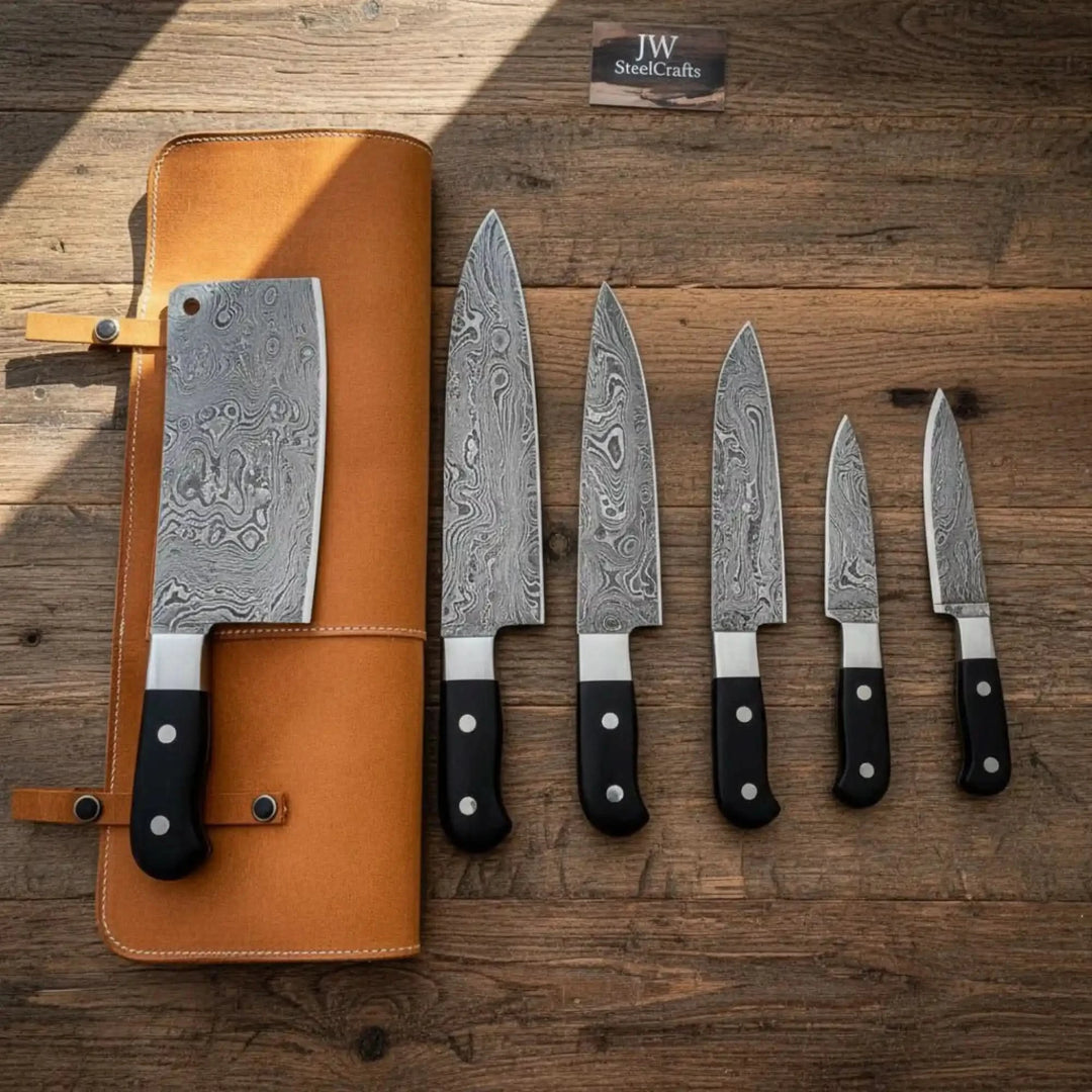 Damascus steel chef knives arranged beside a handcrafted leather knife roll on rustic wood.