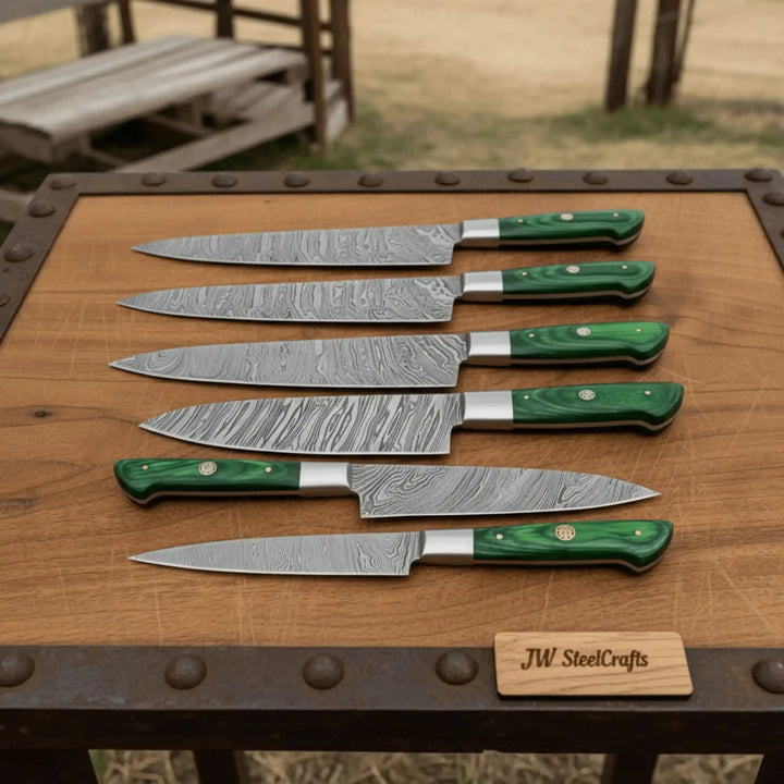 Six Damascus kitchen knives arranged horizontally on rustic wooden cutting board with riveted industrial metal frame.