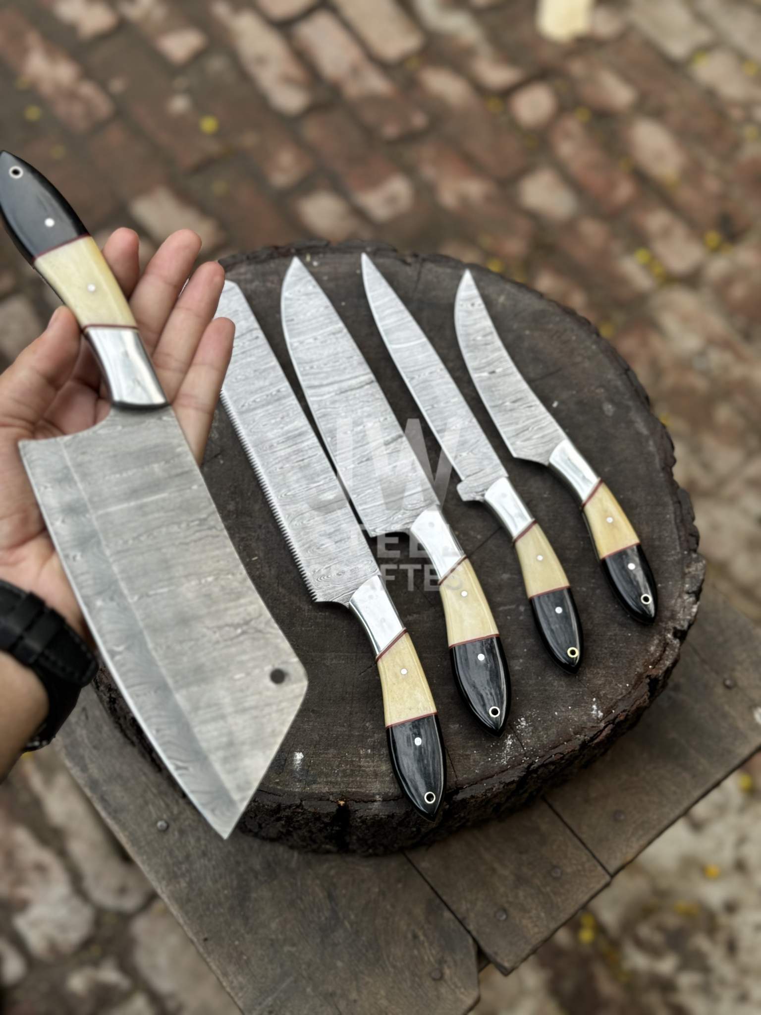 Set of knives with wooden handles on a wooden block outdoors.
