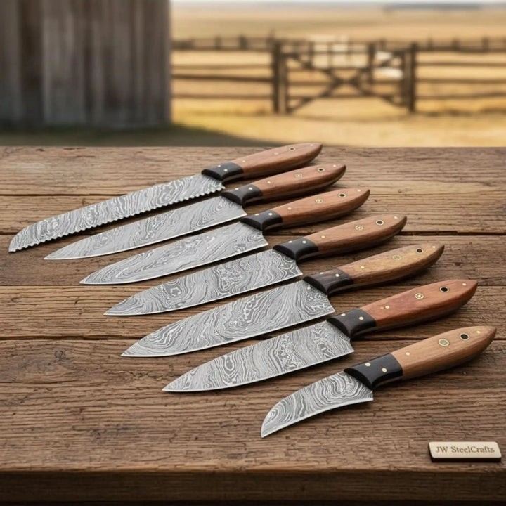Handcrafted steel chef knife set arranged neatly with decorative Damascus blade detailing.