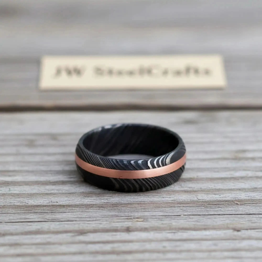 Handmade Damascus Ring Copper Inlay Black And Rose Gold Ring On A Wooden Surface
