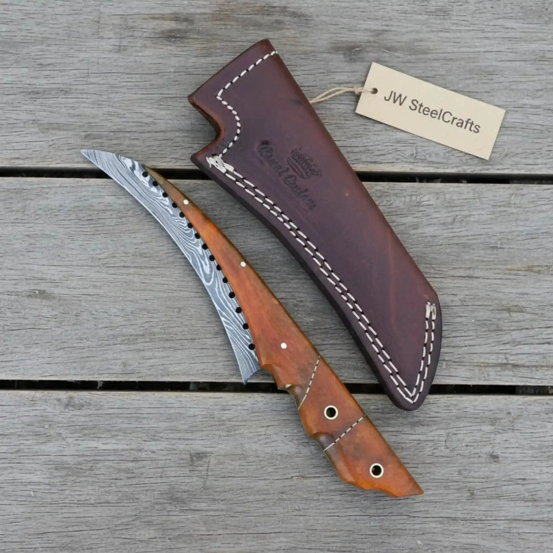 Handmade Damascus Steel Bushcraft Knife With Brown Handle And Leather Sheath On A Wooden Surface, Featuring 'JW SteelCrafts' Branding.
