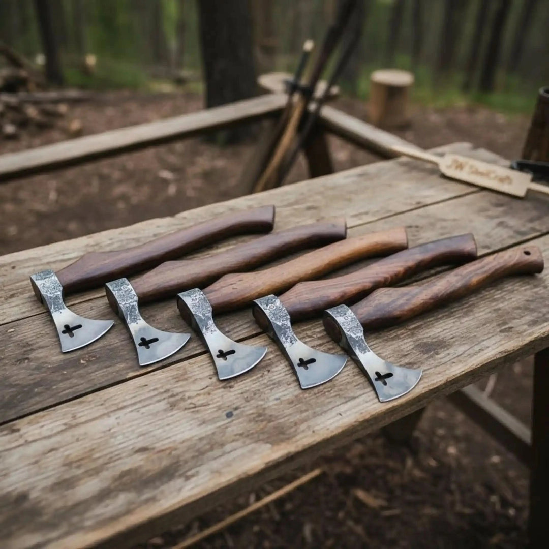     Set of handcrafted mini Viking throwing axes with wooden handles displayed on a rustic outdoor wooden table in a forest setting.