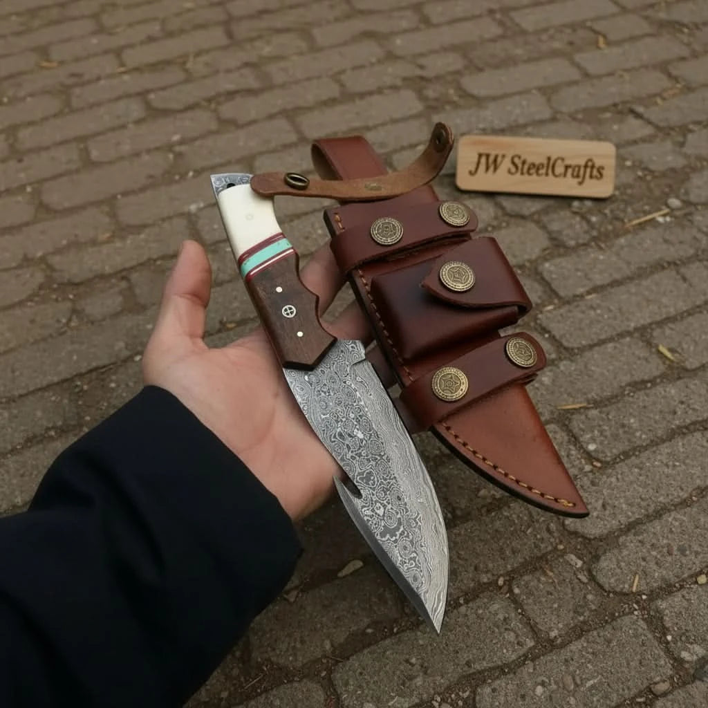 Handmade fixed blade Damascus gut hook knife with patterned steel blade, decorative wood handle, and leather sheath on a log.