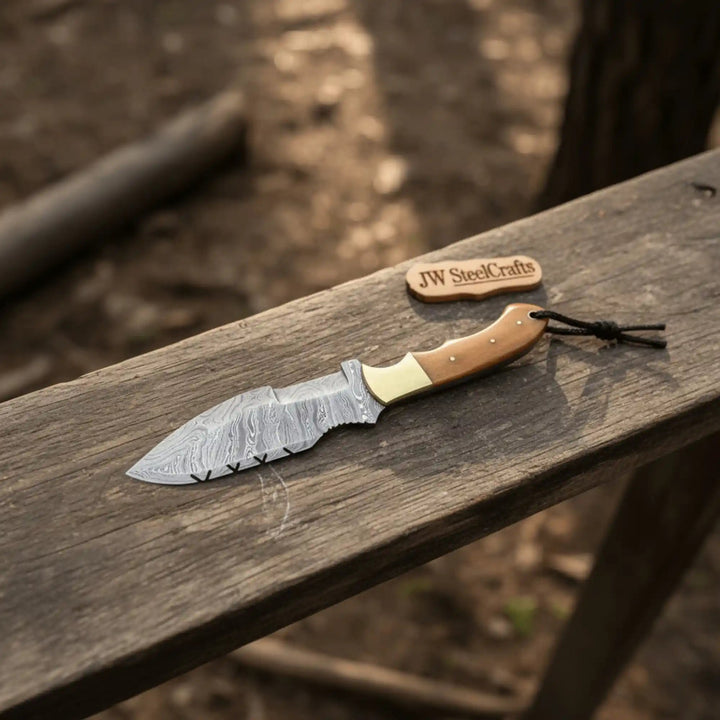 Brown wood handle Damascus knife paired with tooled leather sheath and matching patterned steel blades.