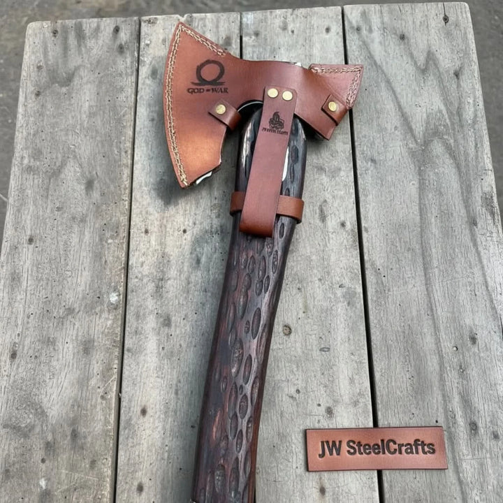 Jade-style Norse steel axe display showcasing intricate Nordic engravings and rustic leather accessories.