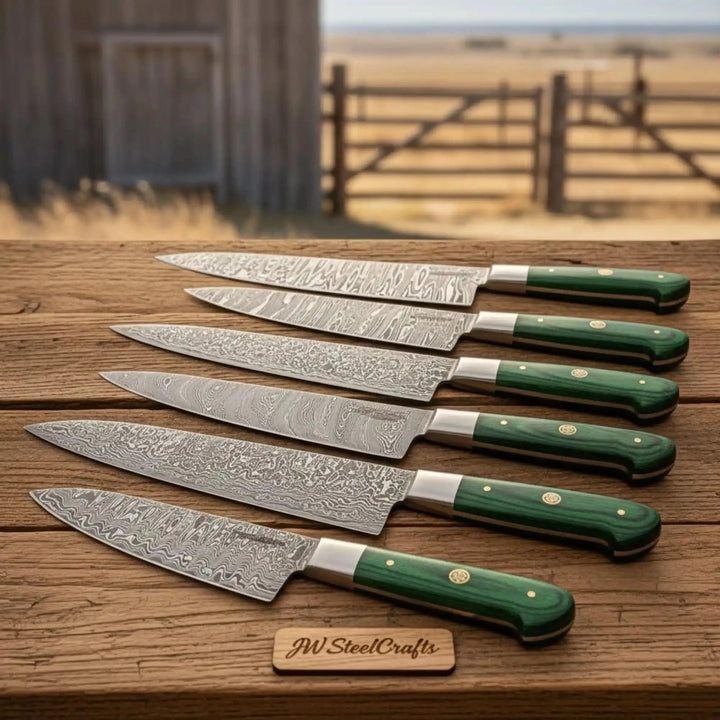 Artisan Damascus kitchen knives displayed outdoors on rustic wooden tabletop.