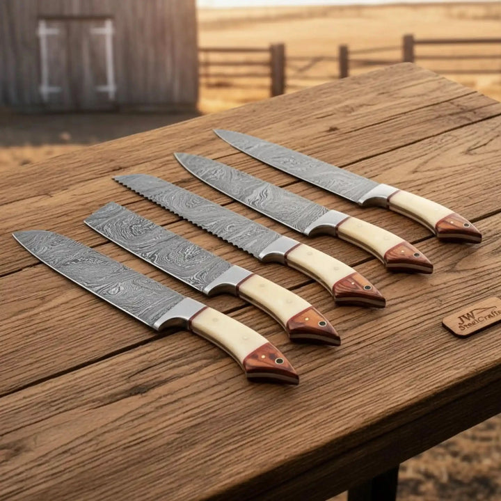 Damascus cutting knife set with sharp steel edges and handcrafted cream handles.