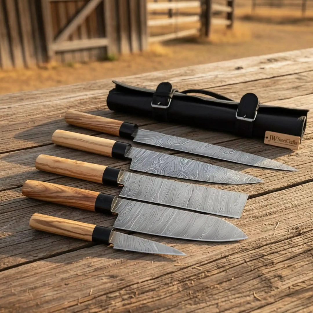 Wood handle Damascus knives arranged on a rustic table with leather knife storage.