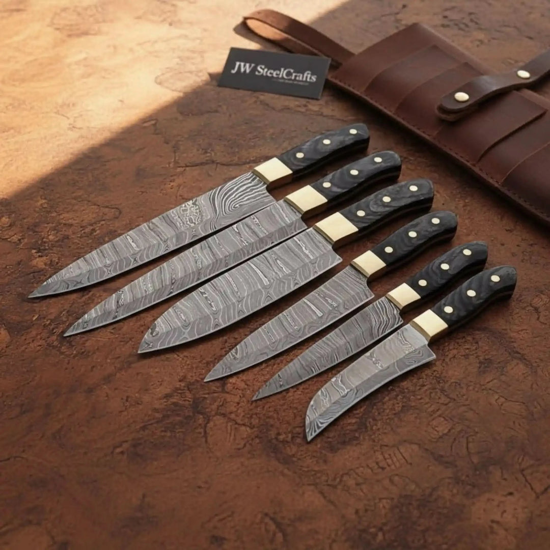 Black grip Damascus knives with sharp steel blades and smooth ergonomic styling.