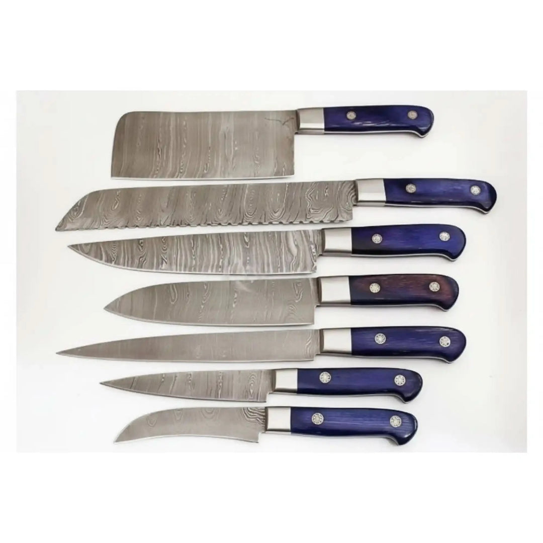 Seven Damascus steel kitchen knives arranged horizontally on clean white background with deep blue ergonomic handles.