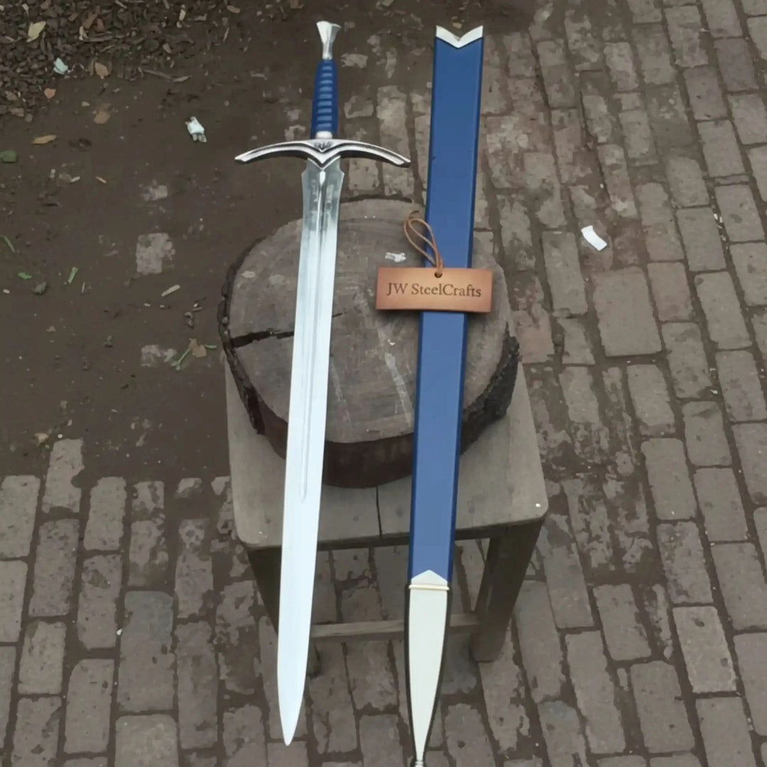 A striking medieval longsword with a polished blade, ornate silver winged crossguard, and blue ribbed handle, paired with a matching blue leather scabbard on a cobblestone surface.