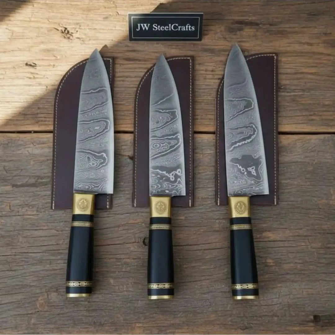 Black gold handle Damascus chef knives displayed on rustic weathered wood in natural light.