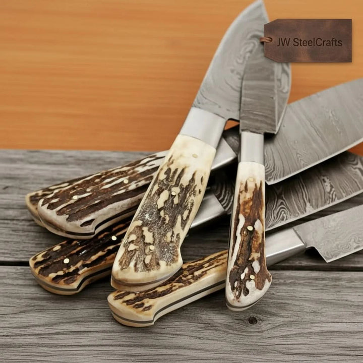 Forged steel kitchen knives photographed in close flatlay angle emphasizing layered blade craftsmanship and rustic styling.