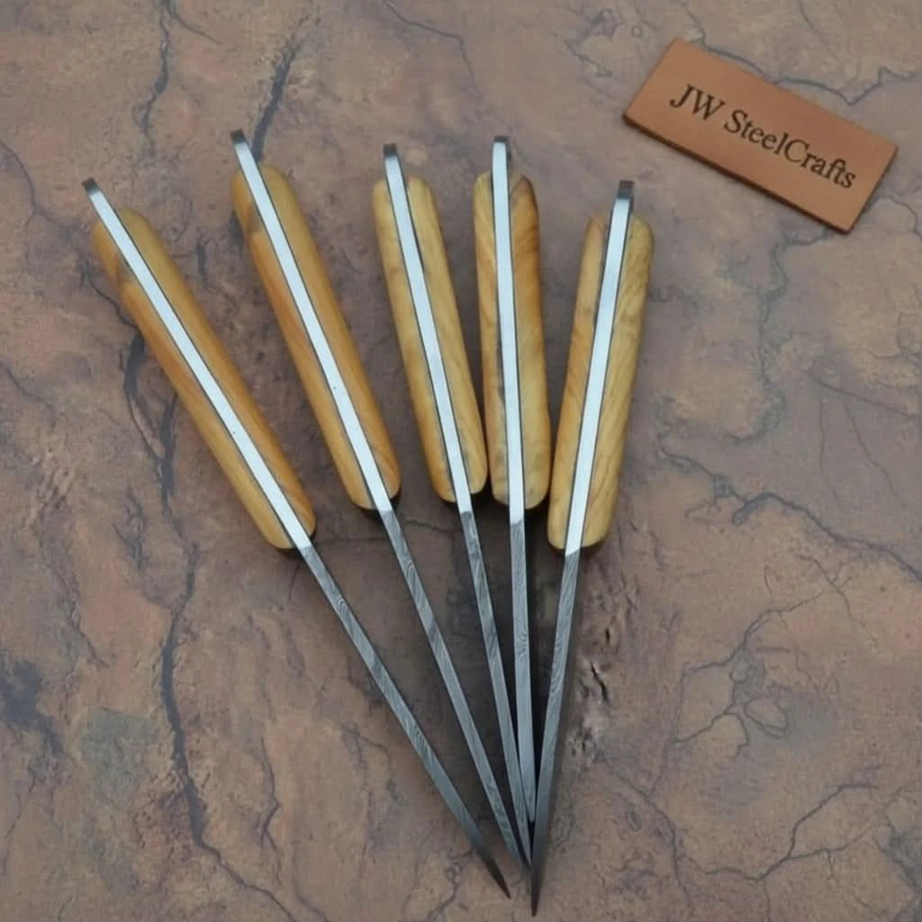 Decorative kitchen blade collection photographed to highlight sharp angular blade tips and layered Damascus textures.