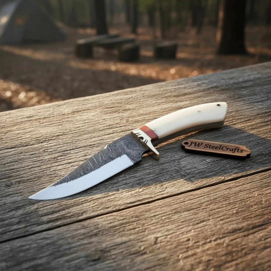 Sunlit JW SteelCrafts ivory knife photo showing a fixed blade knife on aged wood in warm outdoor light.