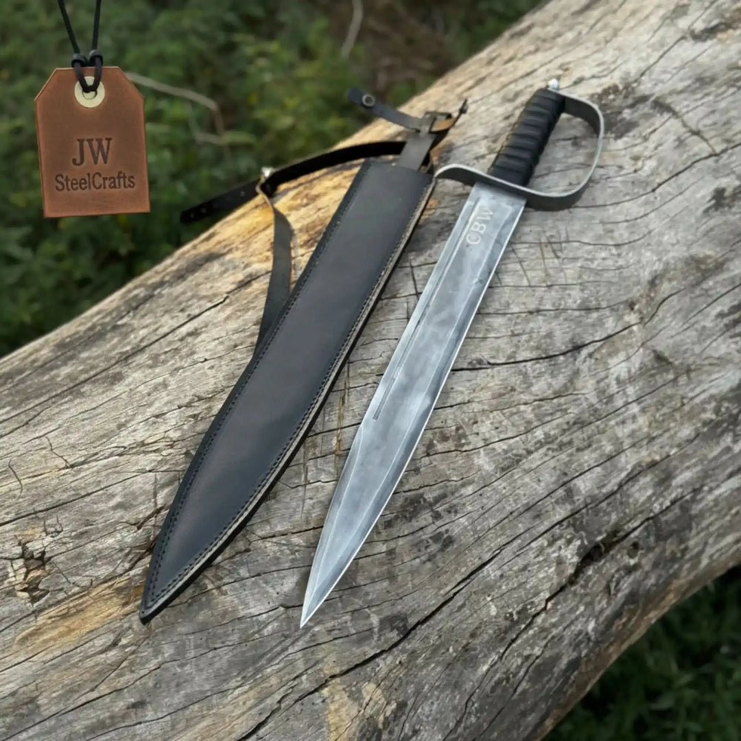 A civil war-style saber with a bright tapered blade, black D-guard, and wrapped handle, displayed alongside its black leather sheath with belt loop on a rustic stump.