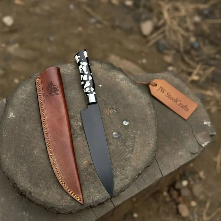 Unique resin handle kitchen knife with black blade and brown leather sheath behind it