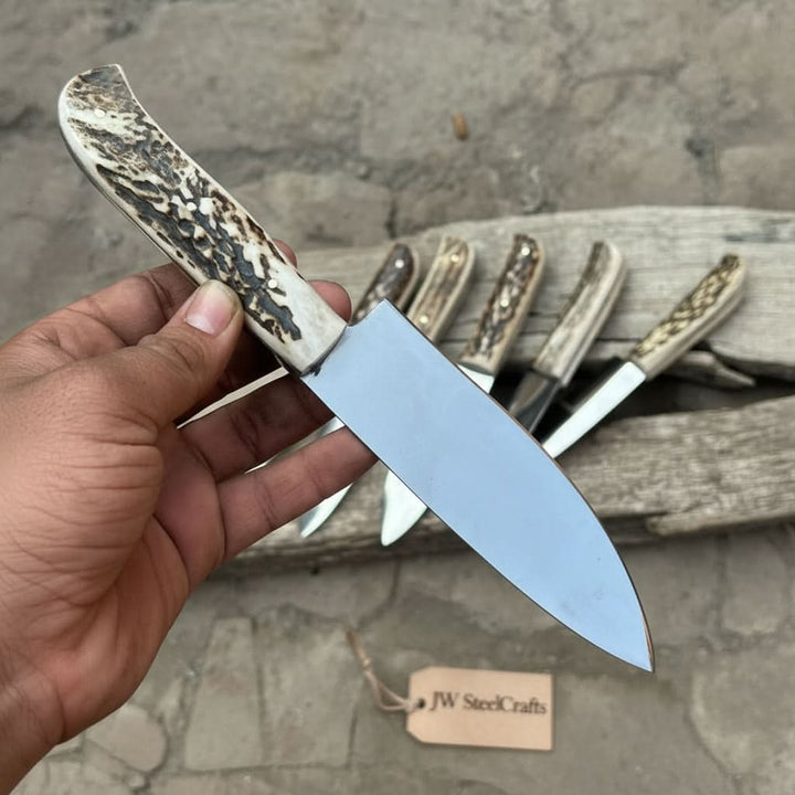 Chef butcher utility knife set with stag handles, polished steel blades, and six knives arranged on rustic wood.
