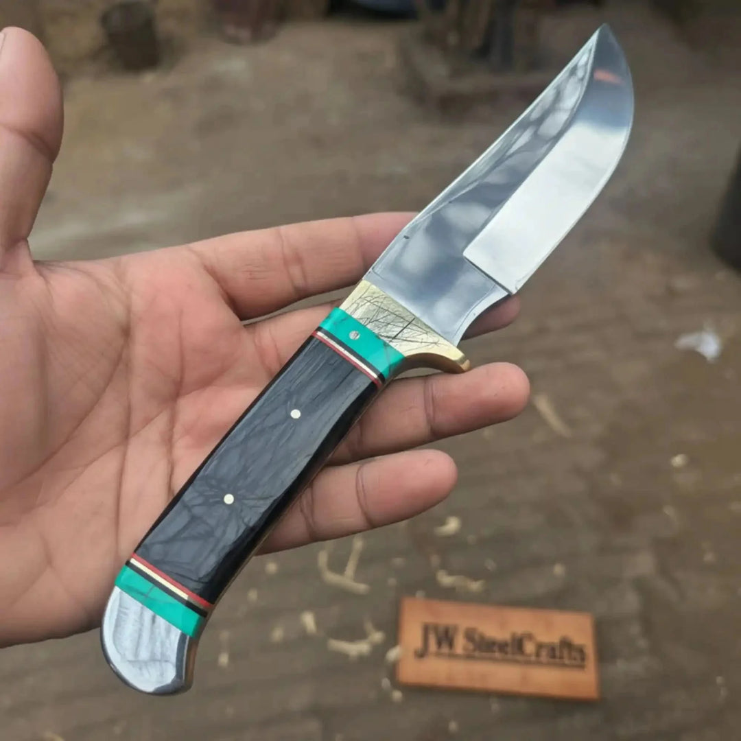 Nightlight Hunter Satin Fixed Blade Frontier Bowie Knife Hand Holding A Knife With A Decorative Handle, Blurred Background