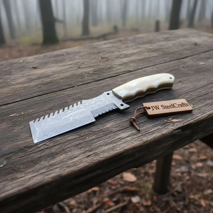 Weathered table Damascus cleaver product photo showing a wide patterned blade and branded wooden tag