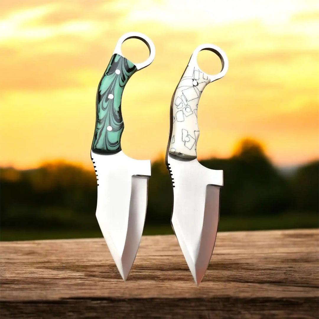 Ivory grip twin push knife set featuring circular ring handles, pointed blades, and contrasting handle patterns.
