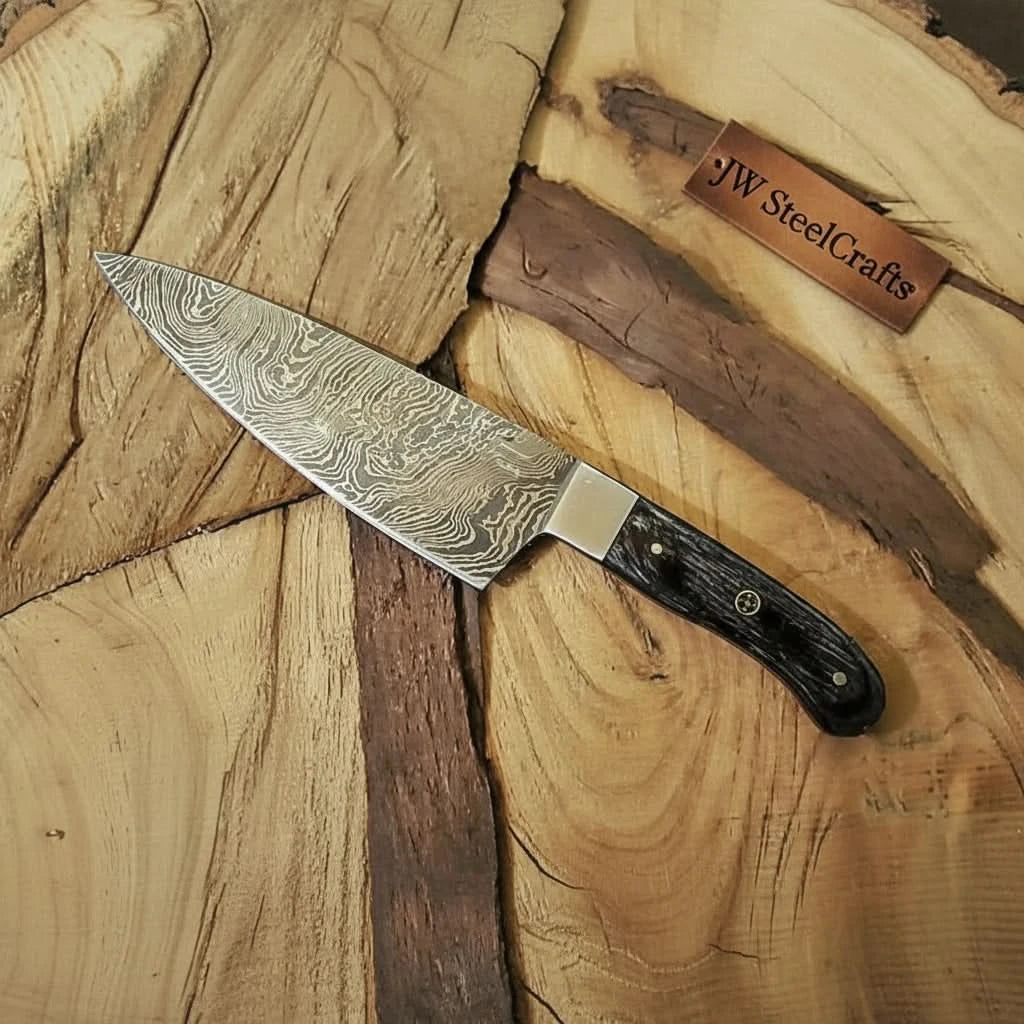 Dark grip Damascus kitchen knife resting on rustic wood with visible grain contrast