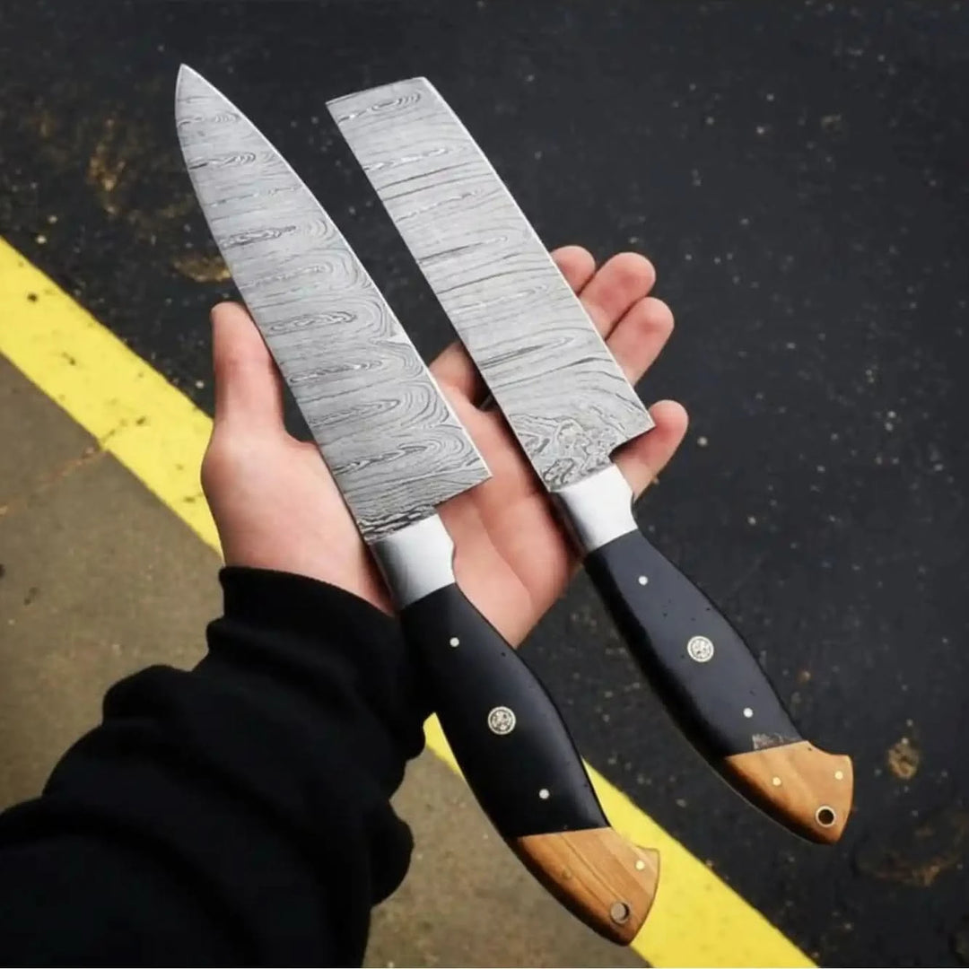 Wood end cap Damascus knife pair with black handle scales and decorative rivets